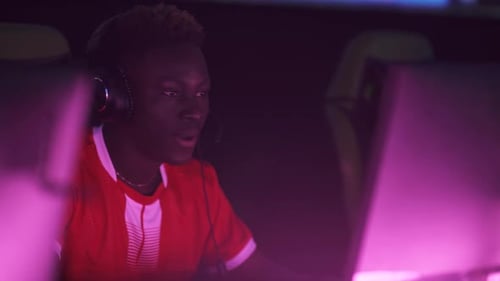 Young Adult Celebrates Gaming Success in Cyber Cafe