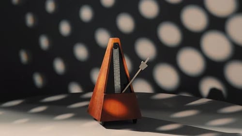Working Metronome Rotates 360 Degrees on a Dark Background with White Rings