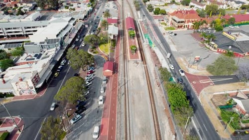 Luftaufnahme eines Bahnhofs, umgeben von Straßen und Gebäuden in einem Vorort