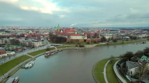 Backward dolly shot over Vistula river and Krakow Wawel Royal Castle, city center fortress with the