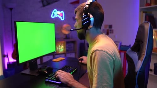 Pro Gamer Streaming Video Games with Green Screen Mockup Display in Gaming Home Studio Chroma Key