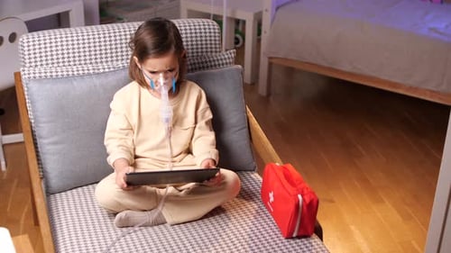 Girl Uses Tablet with Nebulizer Treatment at Home