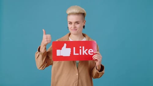 Smiling Woman Holding 'Like' Sign in Studio