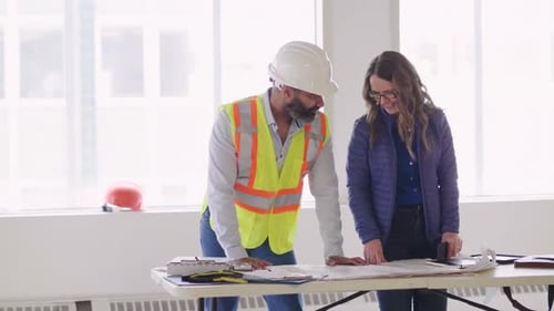 Architects Reviewing Plans in Bright Construction Office