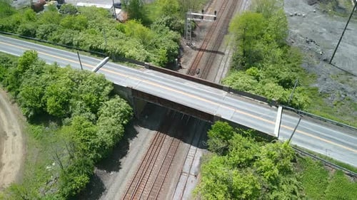 Drohnenaufnahme einer Brücke, die über eine Eisenbahn führt.