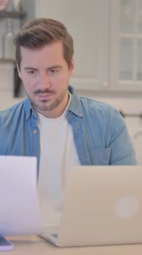 Man Celebrates Success While Working on Laptop