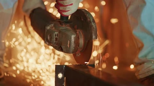 Industrial Setting Where Technician Uses Grinder to Smooth Metallic Flange with Sparks Flying