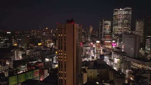 Fly Around High Rise Building in Night City Illuminated Modern Tall Residential Towers in Background