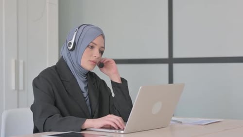Muslim Businesswoman with Headset Talking with Customers Online in Call Centre
