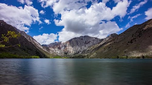 Time Lapse - Panoramic view of tranquil lake with beautiful clouds and snowy mountains