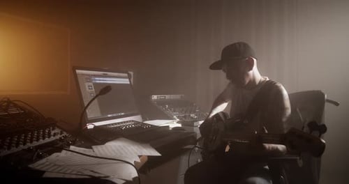 Musician Composing Music with Guitar in Studio