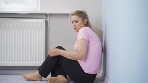 Distressed Woman Hiding in Corner of Room
