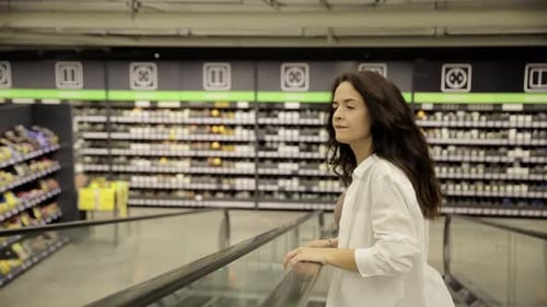 A Woman in a Hardware Store Chooses Wallpaper for Repair Reconstruction and Repair of the House