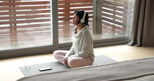 Woman Meditating Indoors Taking Sip of Water