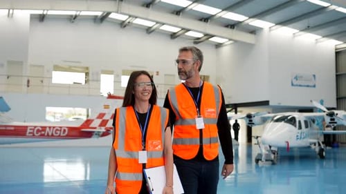 Técnicos de aviación inspeccionando aviones en un hangar