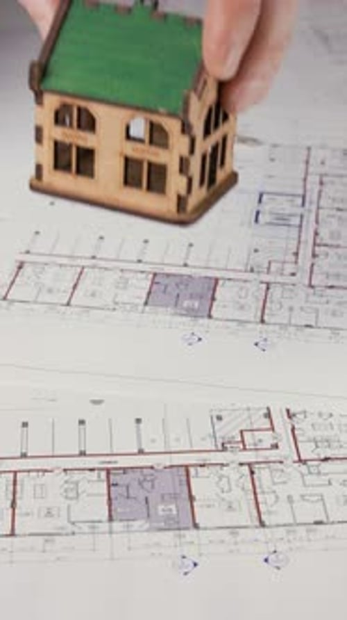 House Model Placed on Architectural Blueprint