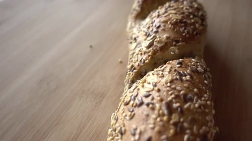 Seeded Baguette Being Sliced on Cutting Board