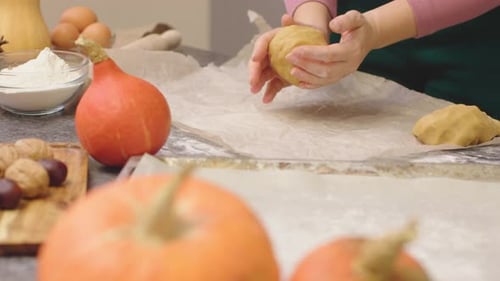 Hands Shaping Pumpkin Dough at Home
