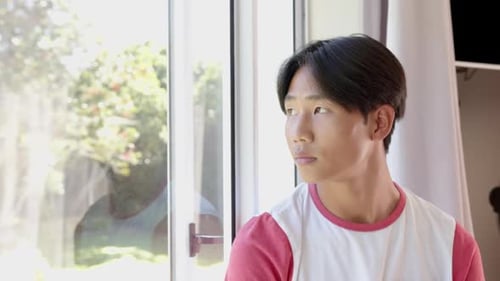 Man Contemplates by Bright Window on Sunny Day