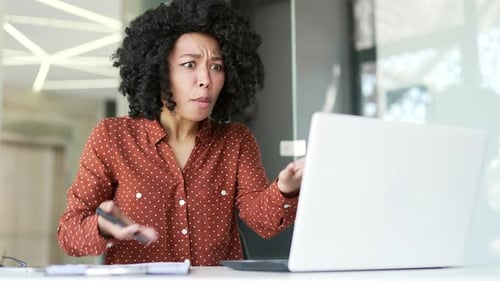 Frustrated Woman Arguing at Laptop in Bright Office