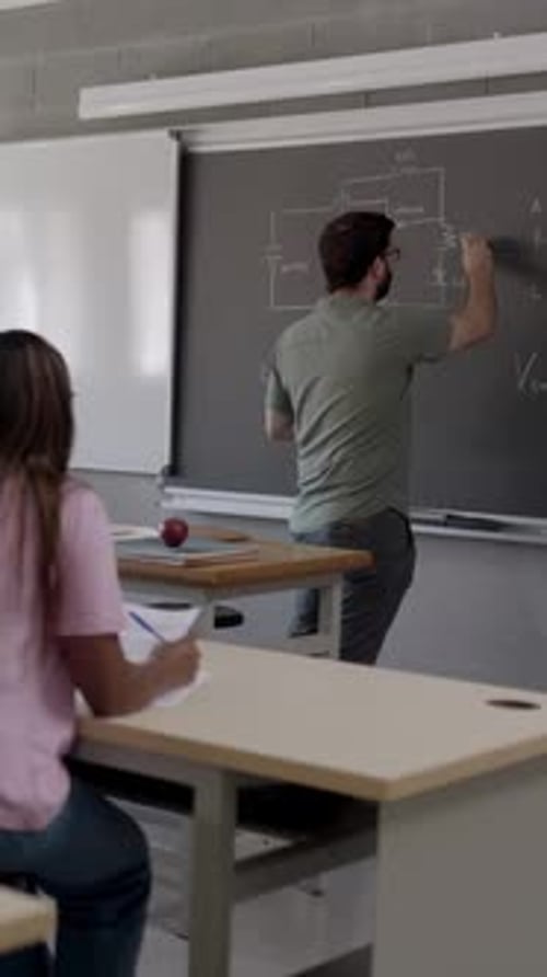 Teacher Writes Equations on Chalkboard for Student