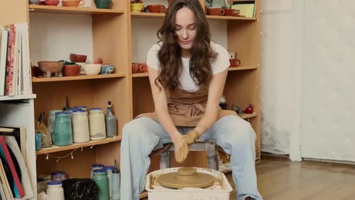 Young Woman Shaping Clay on Pottery Wheel in Ceramic Workshop Handmade Pottery Process and Creative