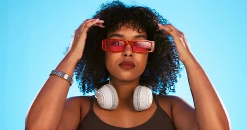 Trendy, gen z and face of a black woman in a studio with accessories, sunglasses and fashion