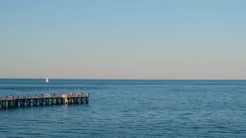 Storm Sea Waves Empty Wooden Pier in Dramatic Blue Sky Background Seascape with Running Splashing