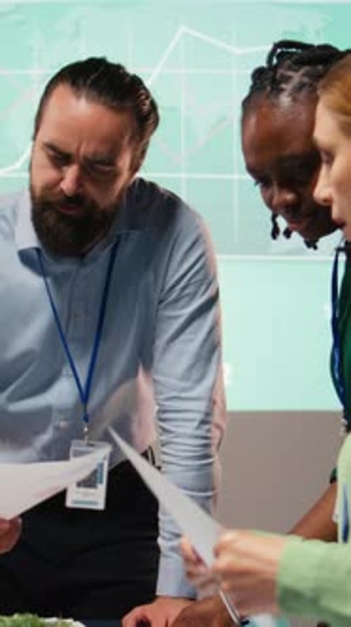 Vertical Video Diverse Group of Professionals Review Files and Performance Metrics