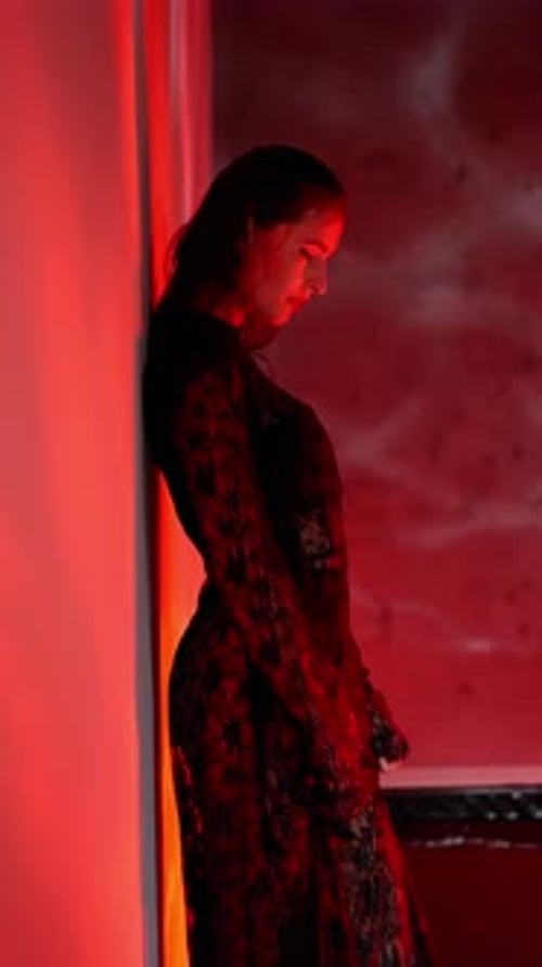 Elegant Woman Posing in Studio with Red Lighting