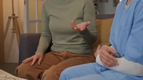 Close-up of Unrecognizable Nurse Supporting Elderly Woman in Retirement Home