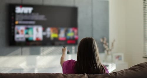 Young Woman Relaxing Watching TV on Couch