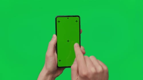 Male Hand Holding a Smartphone with Vertical Green Chroma Key Screen Isolated on Green Mobile Phone