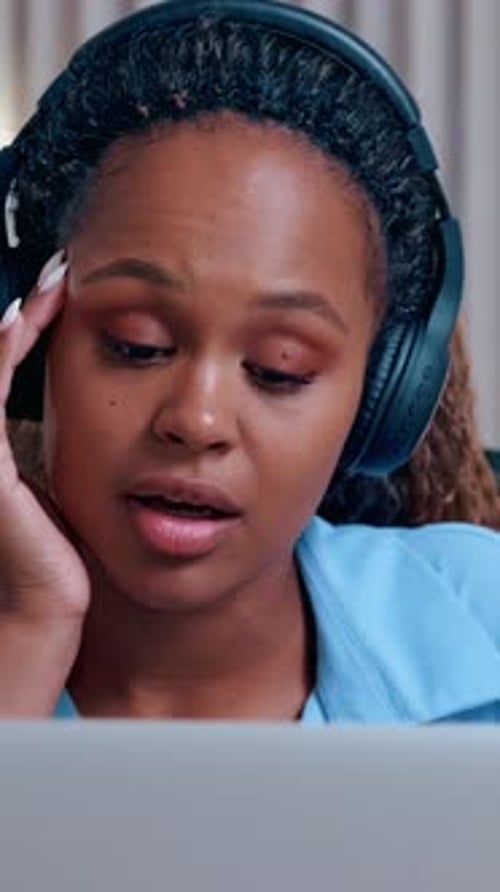 Young Woman Listening to Music on Laptop Indoors