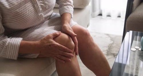 Closeup of a Pensioner's Hands Rubbing a Popliteal or Synovial Cyst a Fluidfilled Swelling That