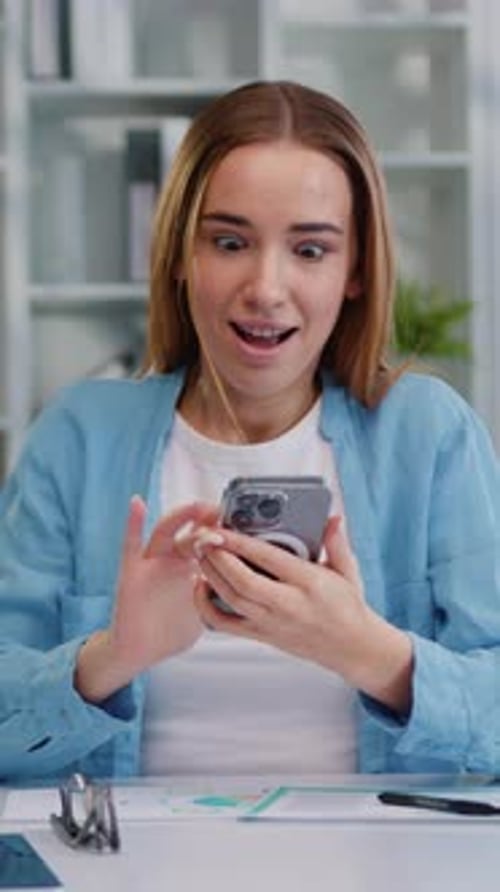 Excited Woman Celebrates Success While Looking at Phone