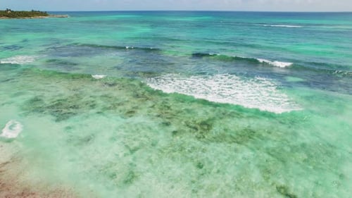 Des vagues se brisent sur un récif turquoise peu profond près de la côte tropicale au Mexique