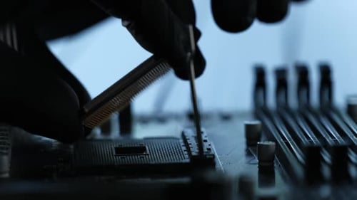 Worker Installing Processor Chip On Motherboard