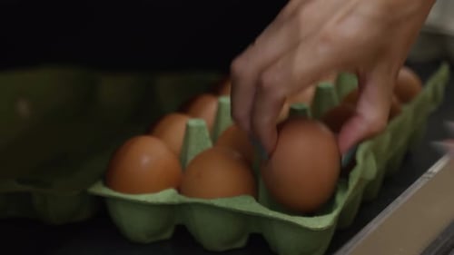 Close Up of Female Hands Choosing Eggs in a Supermarket Girl Holding a Package of Eggs in Her Hands