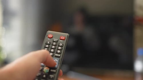 Changing television channels with tv remote controller close-up shot