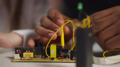 Techniker berührt Dioden mit Sonden und zeigt kleinen Schüler