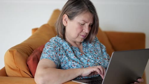 Woman Using Laptop on Mustard Yellow Couch