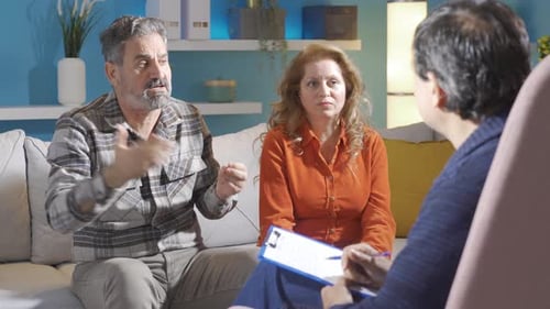 Husband and wife arguing in front of psychiatrist. Domestic discussion.