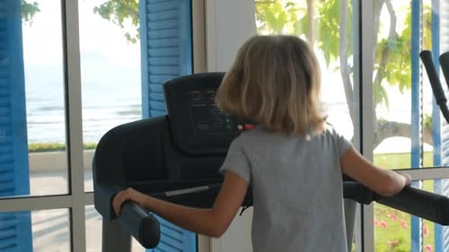 Child Jogging on Treadmill During Sports Training