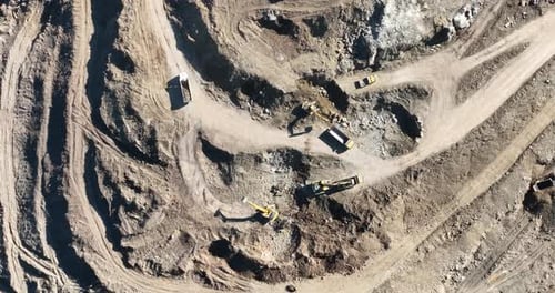 Industrial Mine Excavators are Digging the Soil in the Construction Site and Loading Trucks