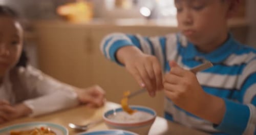 Close Up of a Cute Korean Male Kid Learning How to Use Chopsticks to Eat