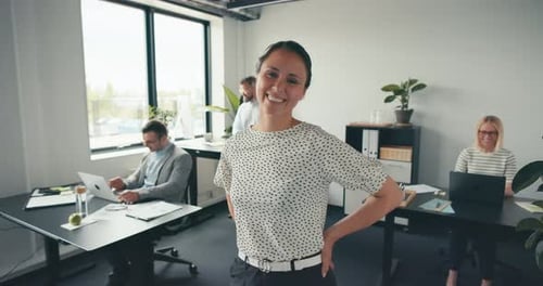 Laughing businesswoman standing confidently in her modern office building