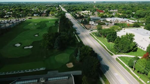 Aerial drone shot over a long highway beside the Golf club in Northbrook Illinois, USA at daytime.