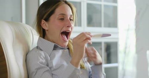 A beautiful woman takes a pregnancy test and as soon as she reads that she is pregnant, she explod