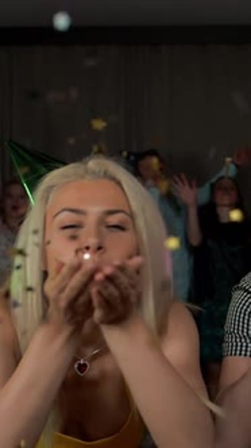 Woman Blows Confetti at Fun Birthday Party